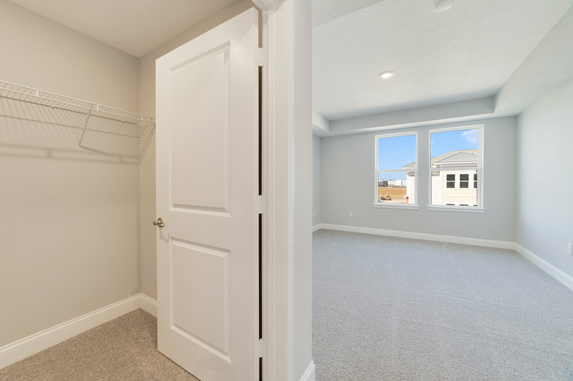 secondary bedroom with tray ceiling, carpet, and two windows