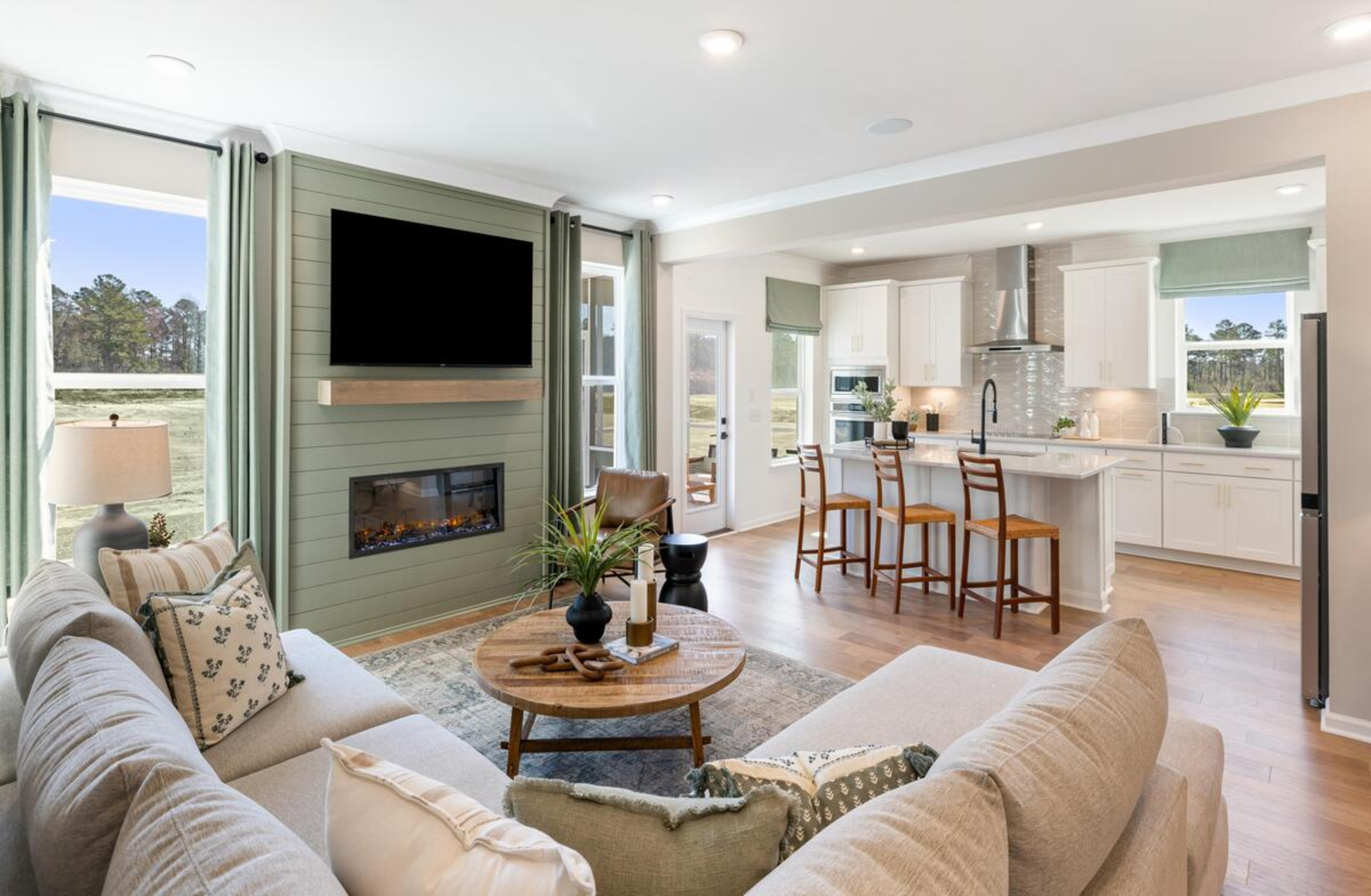 great room with sofa and fireplace open to kitchen