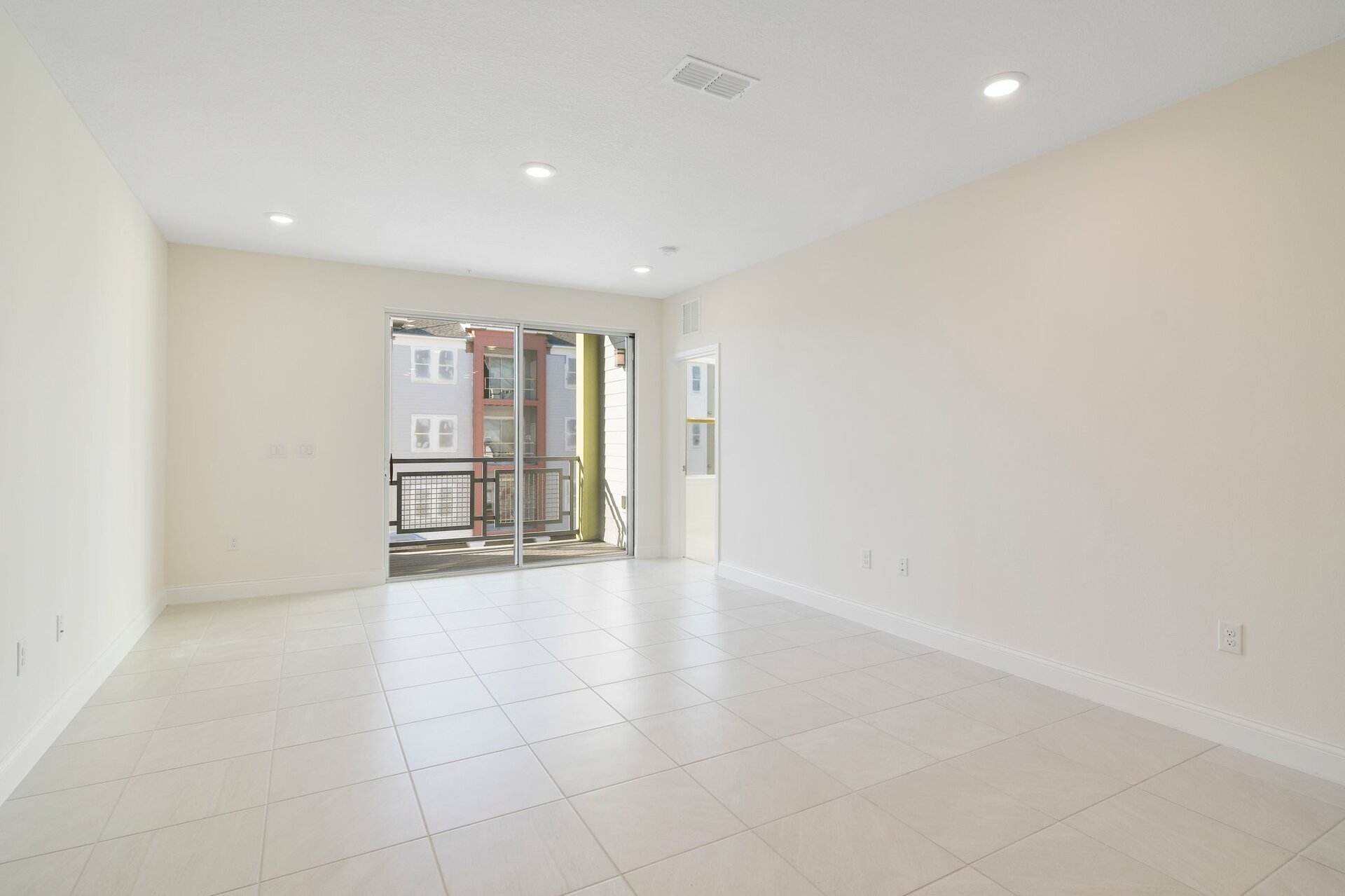 great room with tile flooring and sliding door leading to balcony