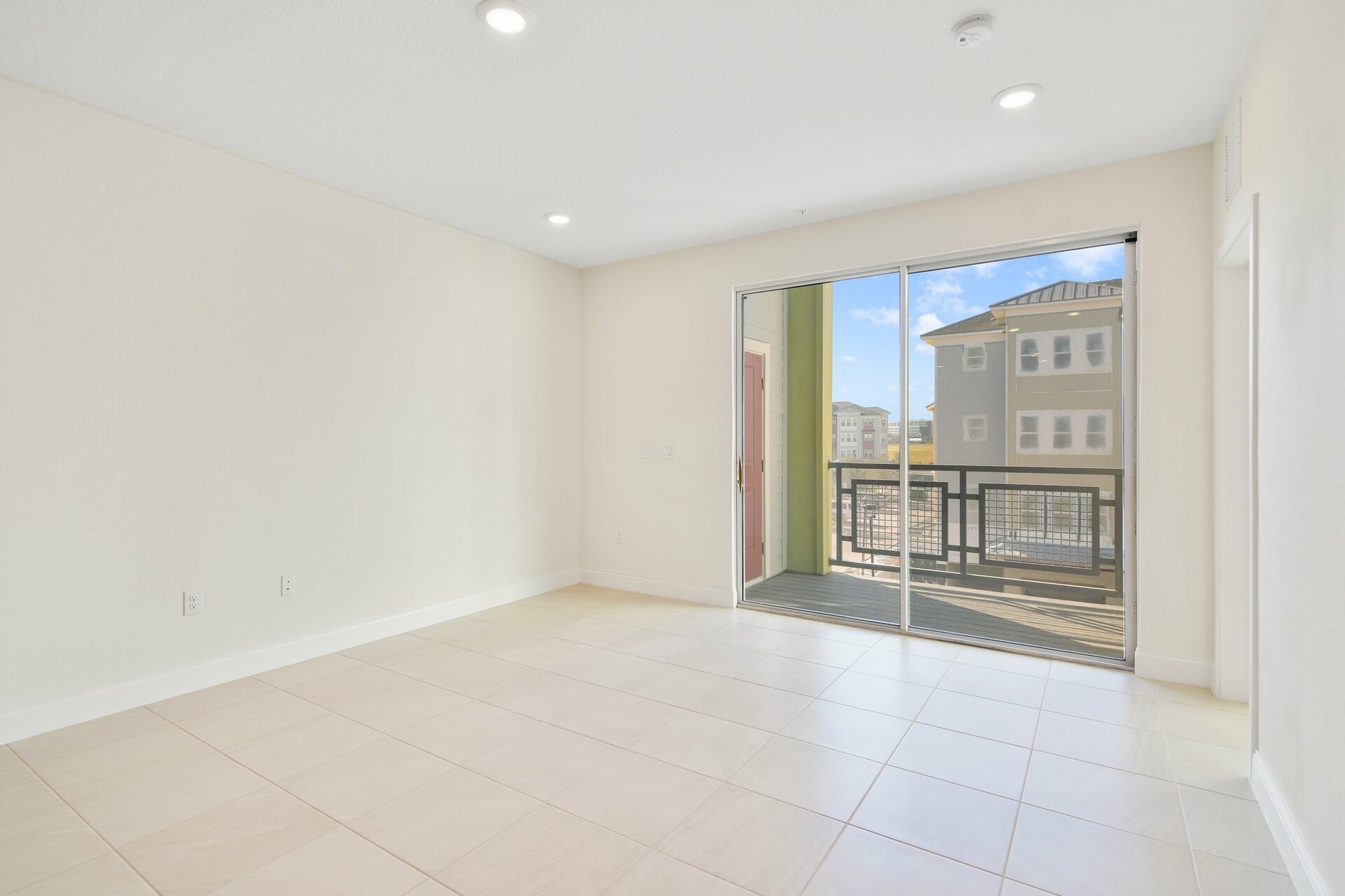 great room with tile flooring and sliding door leading to balcony