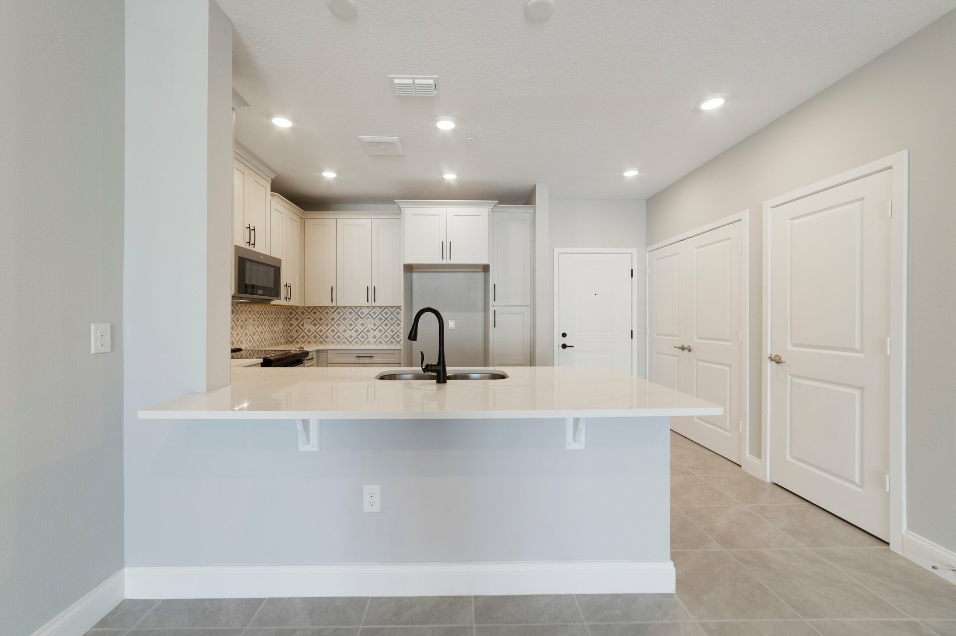 kitchen with gray cabinets, crown molding, and black hardware