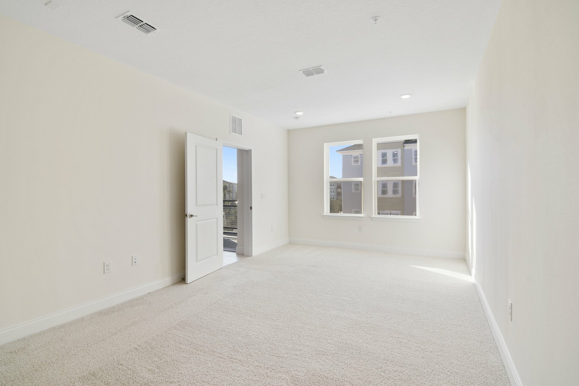 primary bedroom with carpet and two windows