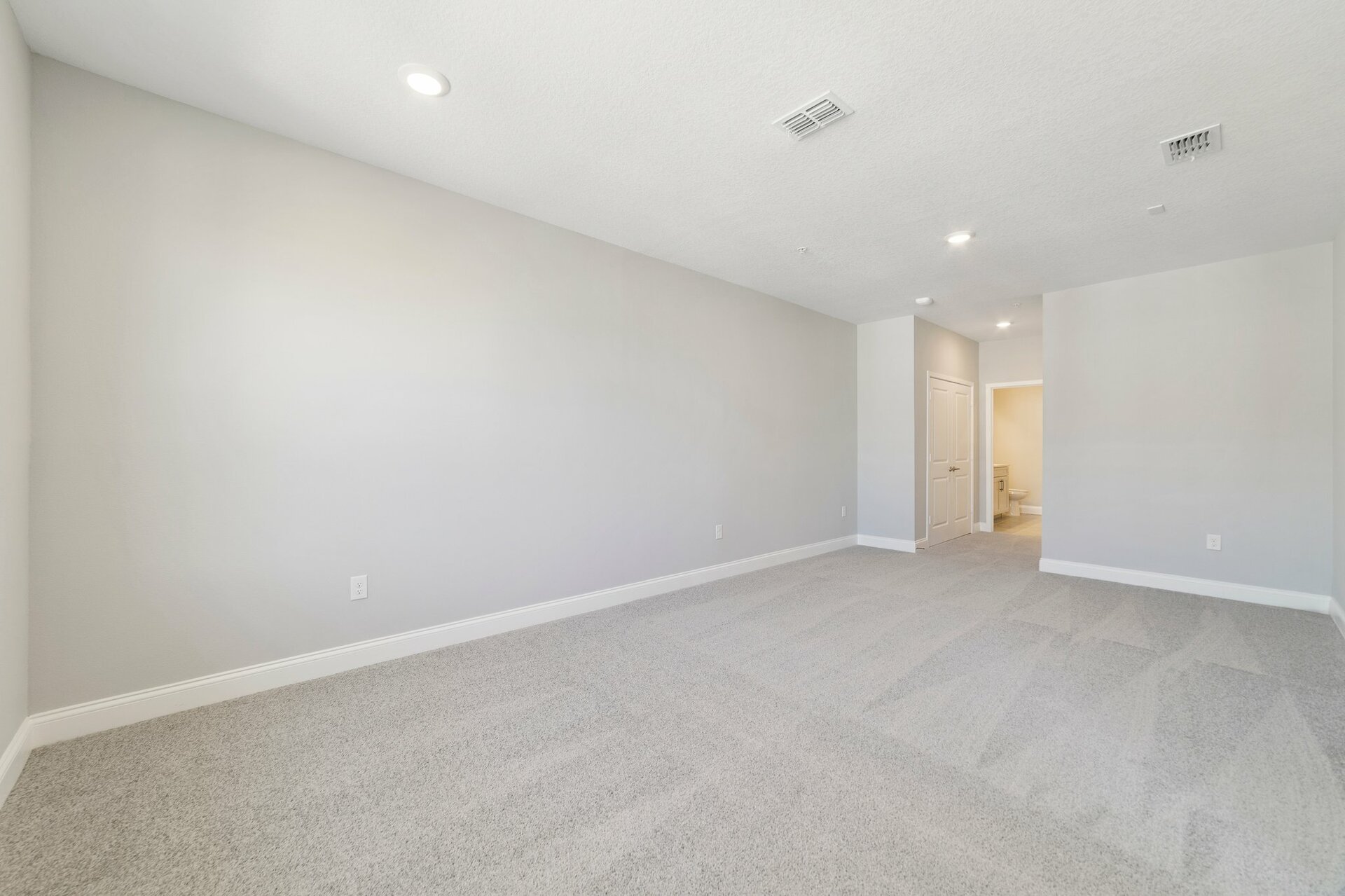 light-filled primary bedroom with carpet and two windows