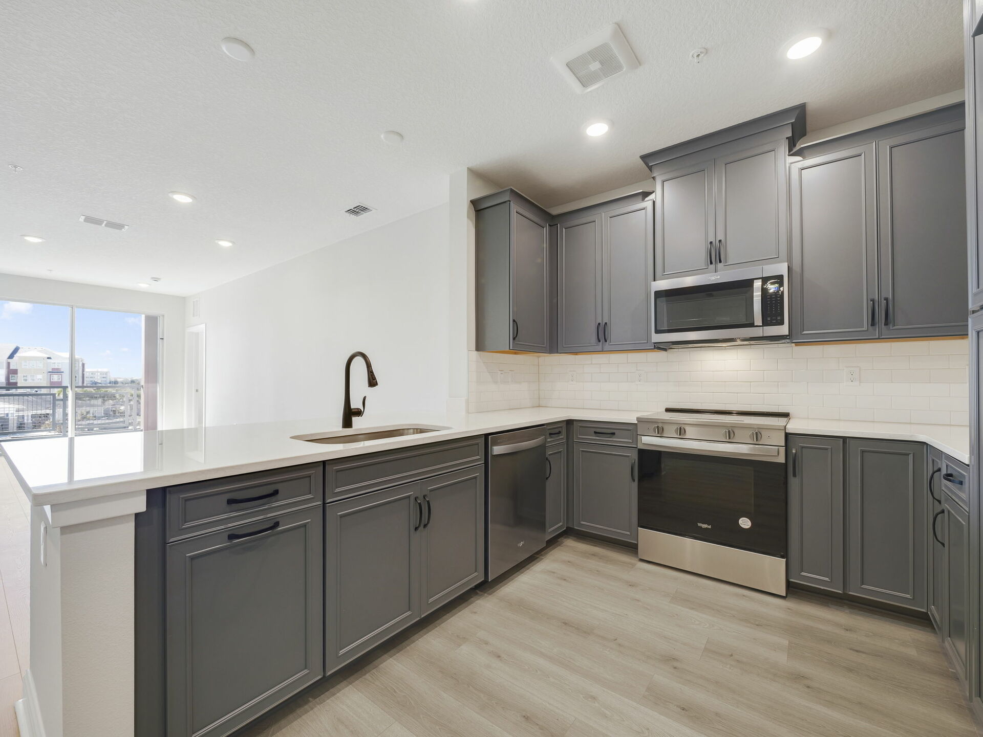  modern kitchen with stainless steel appliances and view of great room 