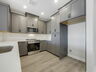  modern kitchen with stainless steel appliances and view of great room 