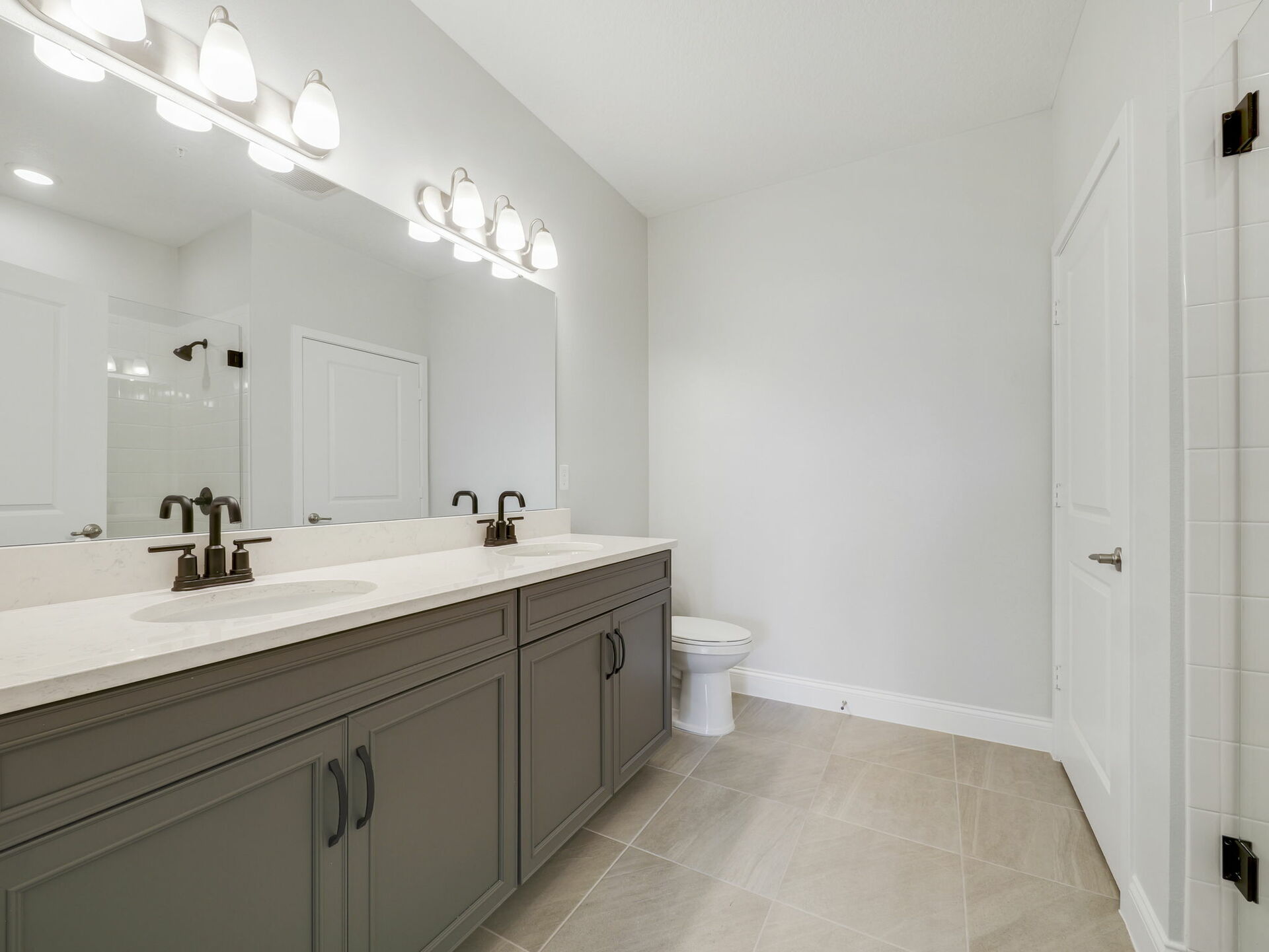 dual sink vanity with water closet and semi-frameless shower 