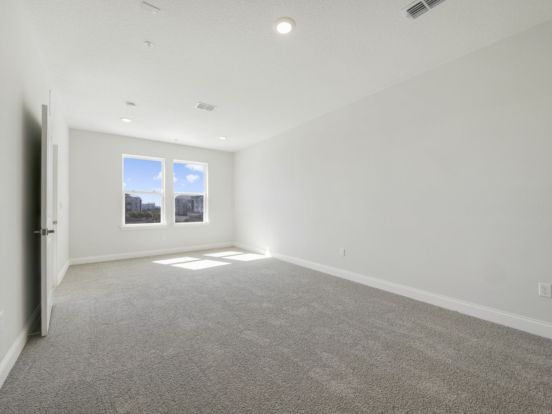 room with carpet throughout and large windows 