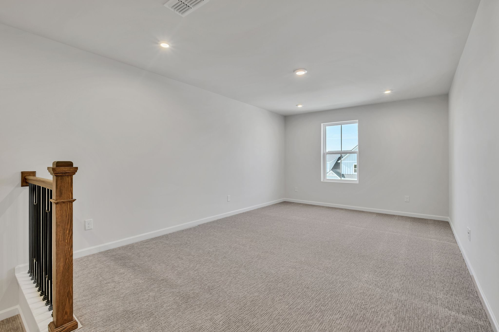 loft space with carpet flooring and a large window