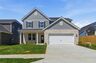 home exterior with brick, gray paneling, covered front porch, and two car garage
