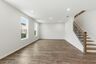 great room with wood flooring, large windows, and a view of the staircase