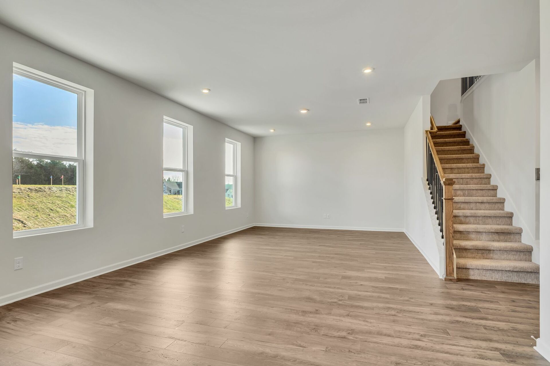 great room with wood flooring and large windows