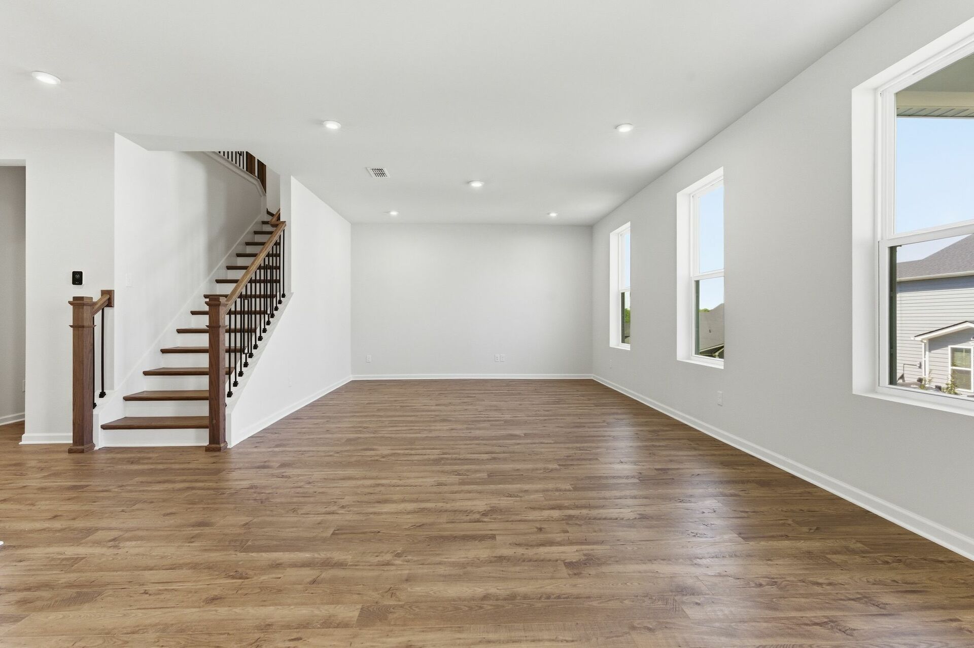 great room with oak wood staircase, and large windows