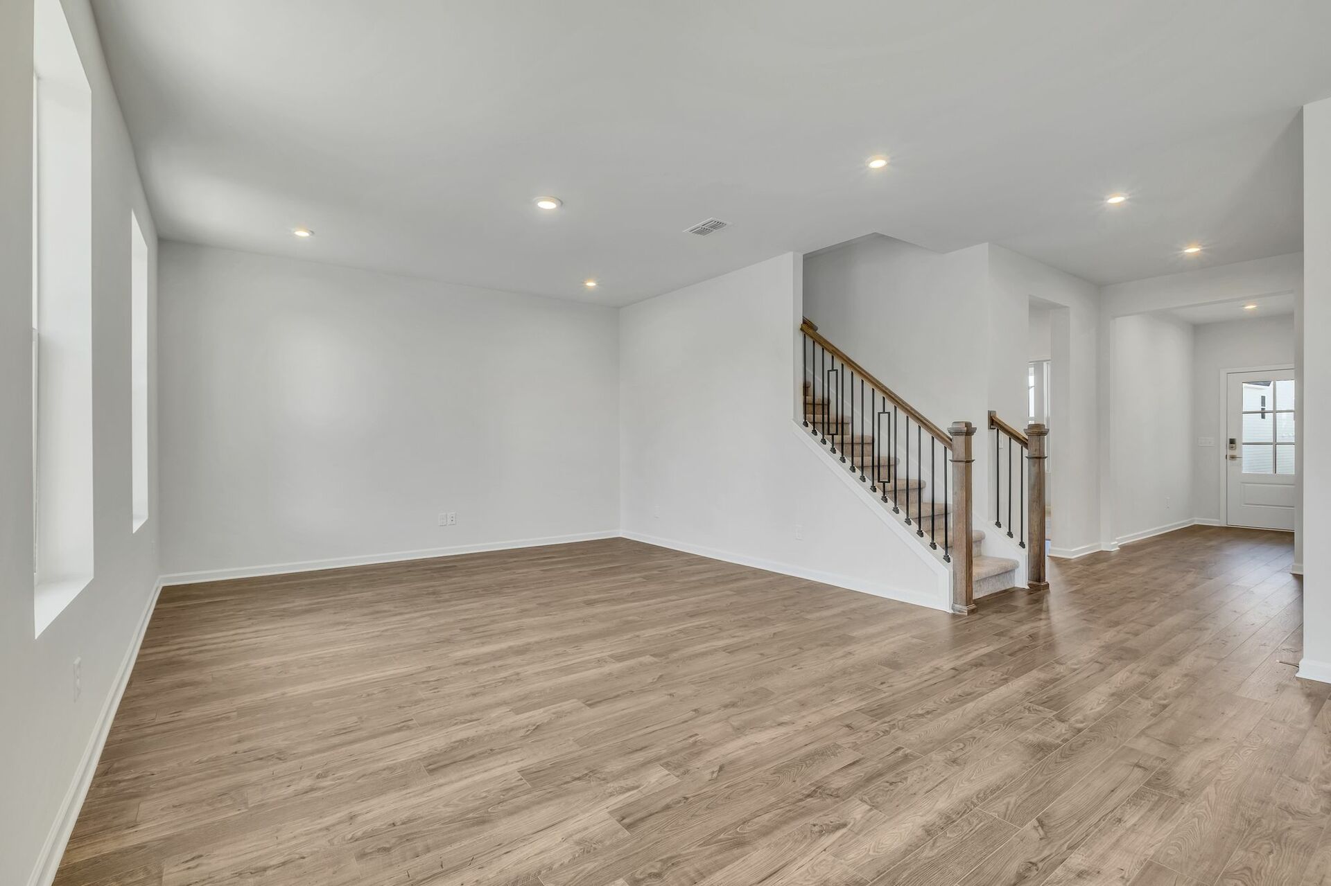 great room with wood flooring and large windows