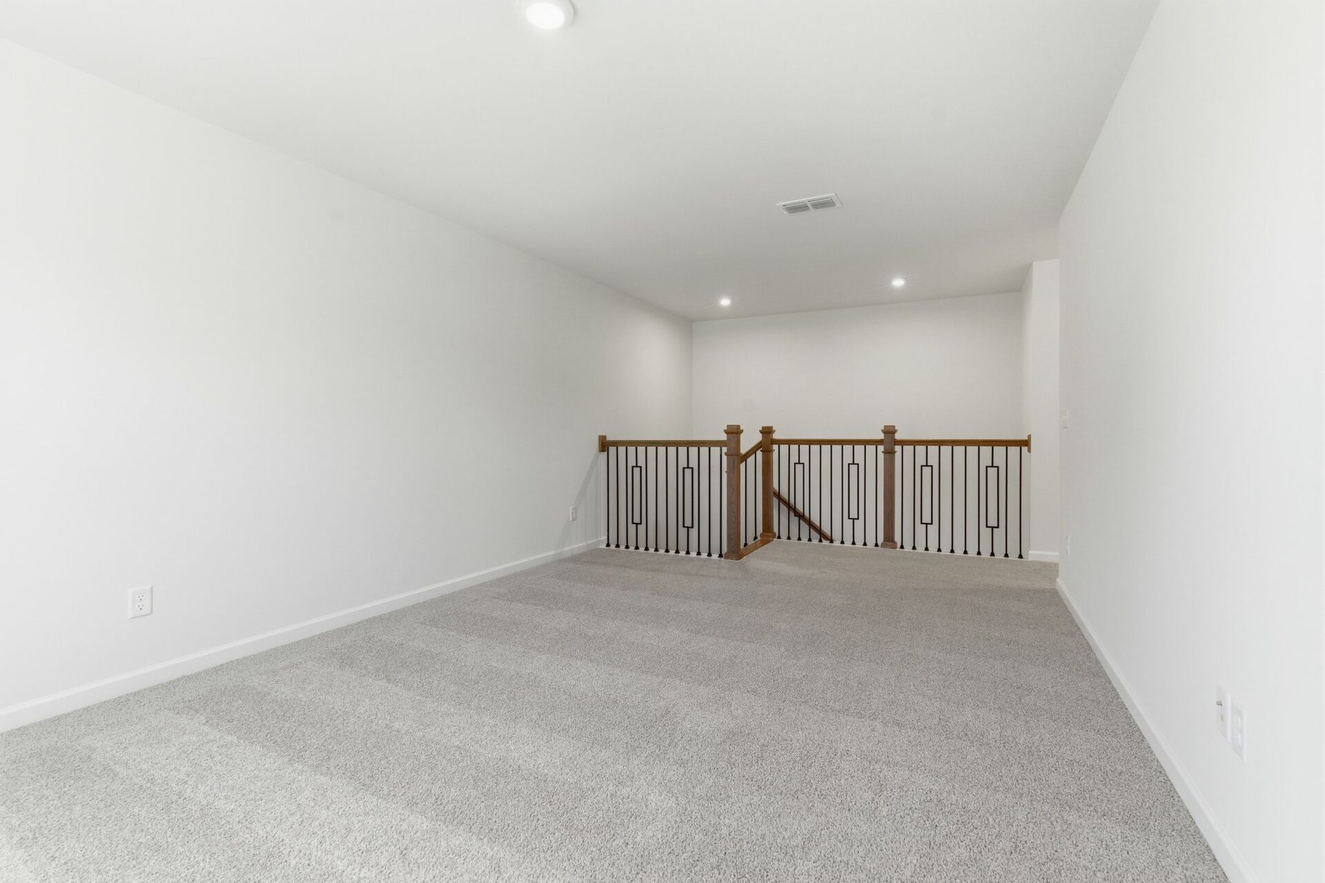 upstairs loft with large windows and carpet