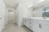 primary bathroom with dual vanity sinks and white cabinetry