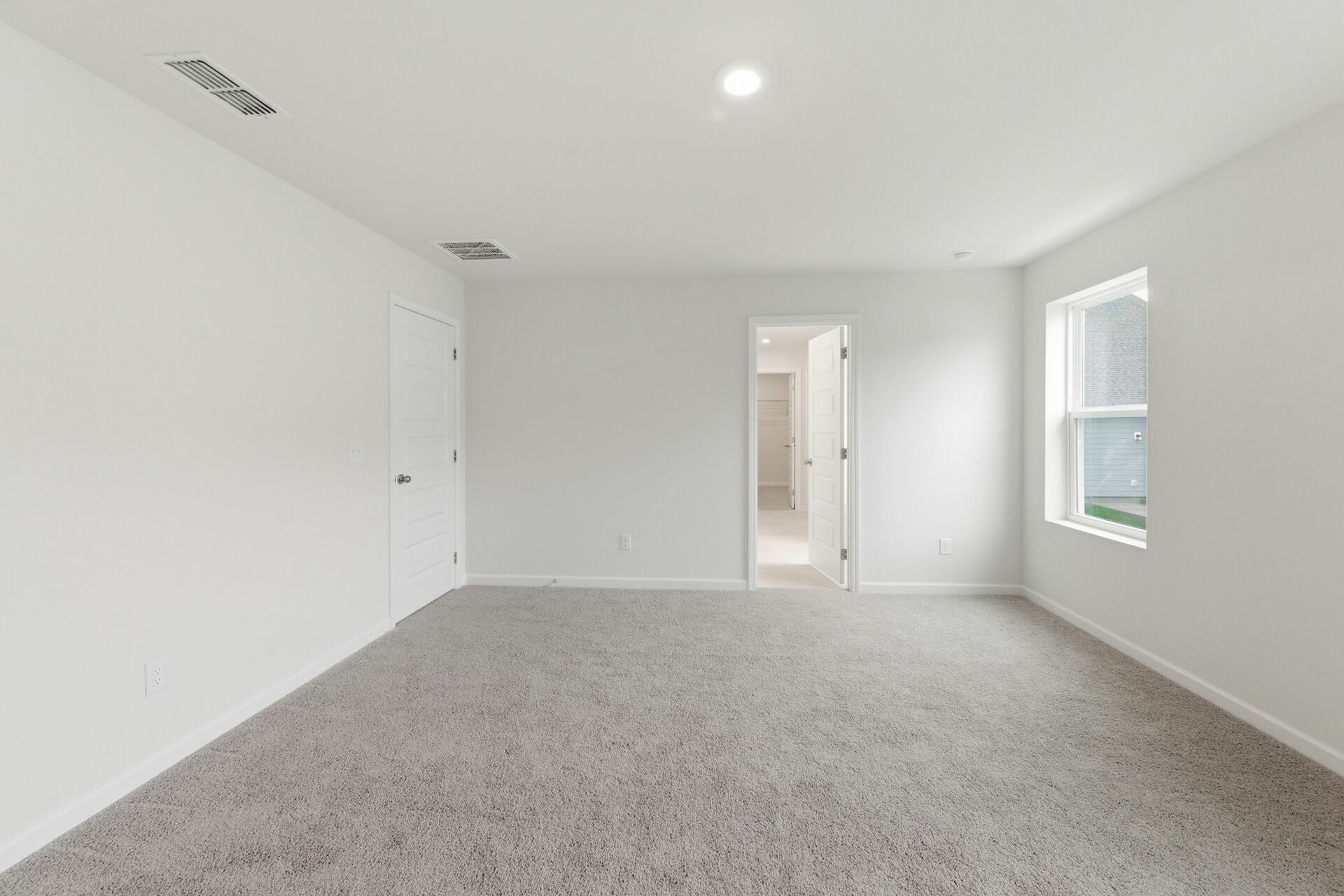 primary bedroom with carpet flooring, white trim, and large windows