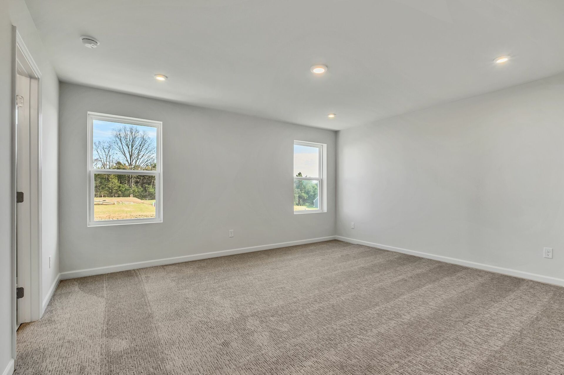 primary bedroom with carpet flooring and light filled windows