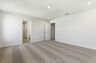 primary bedroom with carpet, large windows, walk-in closet, and attached bathroom