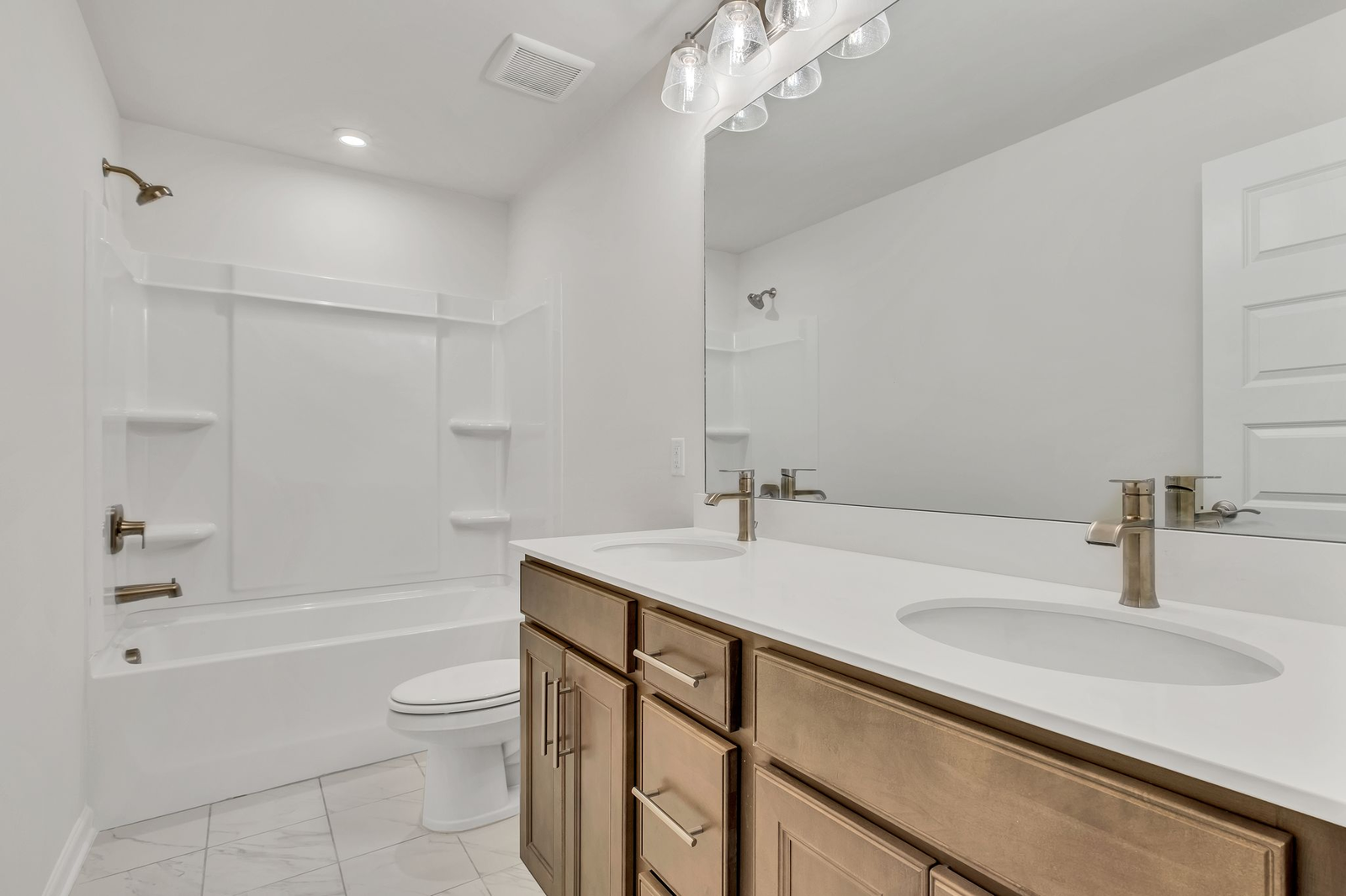 secondary bathroom with wood cabinets and white countertops