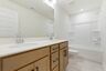 bathroom with dual vanity sinks and wood cabinets