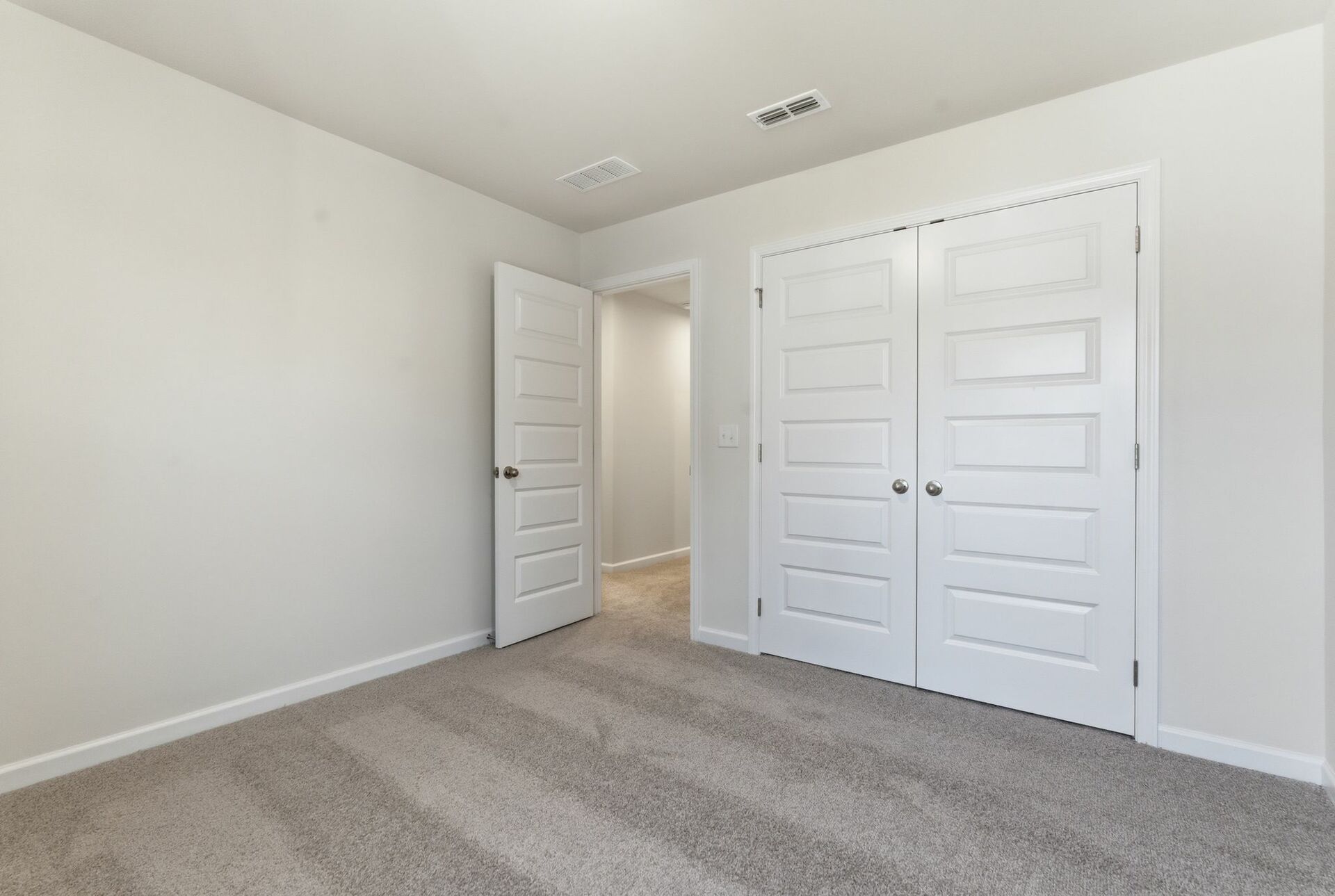 secondary bedroom with large windows and carpet