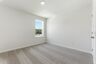 secondary bedroom with large windows, walk in closet, and carpet