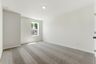secondary bedroom with large windows, walk in closet, and carpet