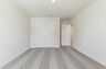 secondary bedroom with large windows, walk in closet, and carpet