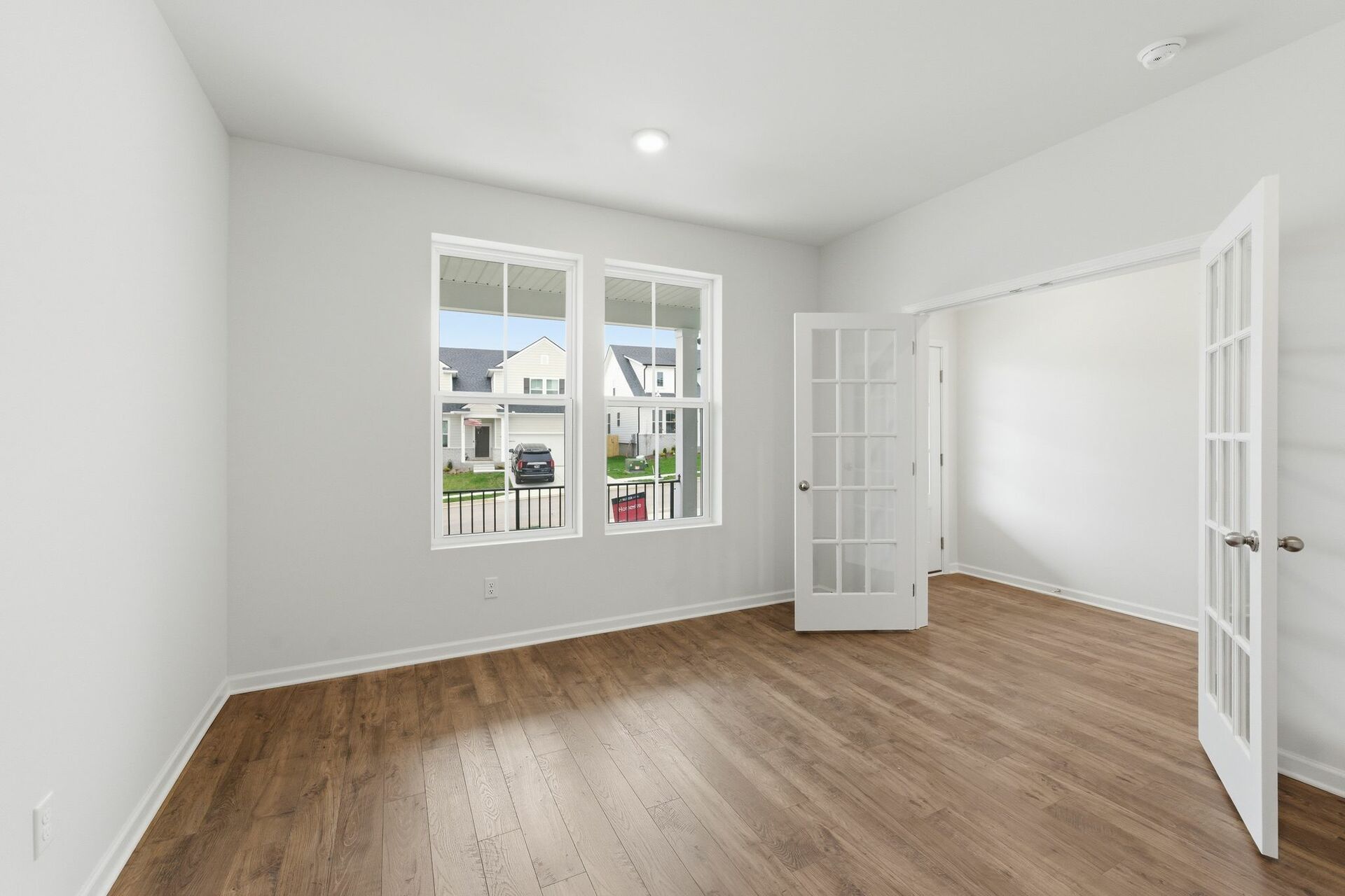 study with wood floors, large windows, and french doors