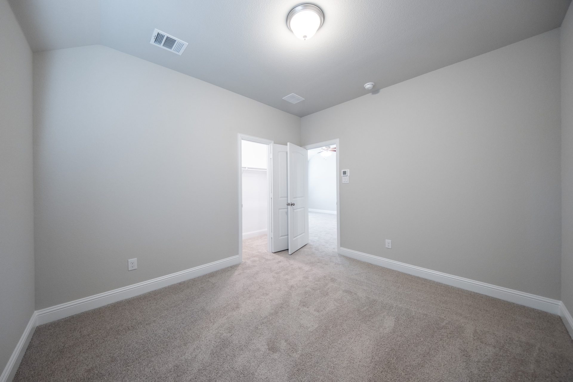 guest bedroom with carpet and walk-in closet
