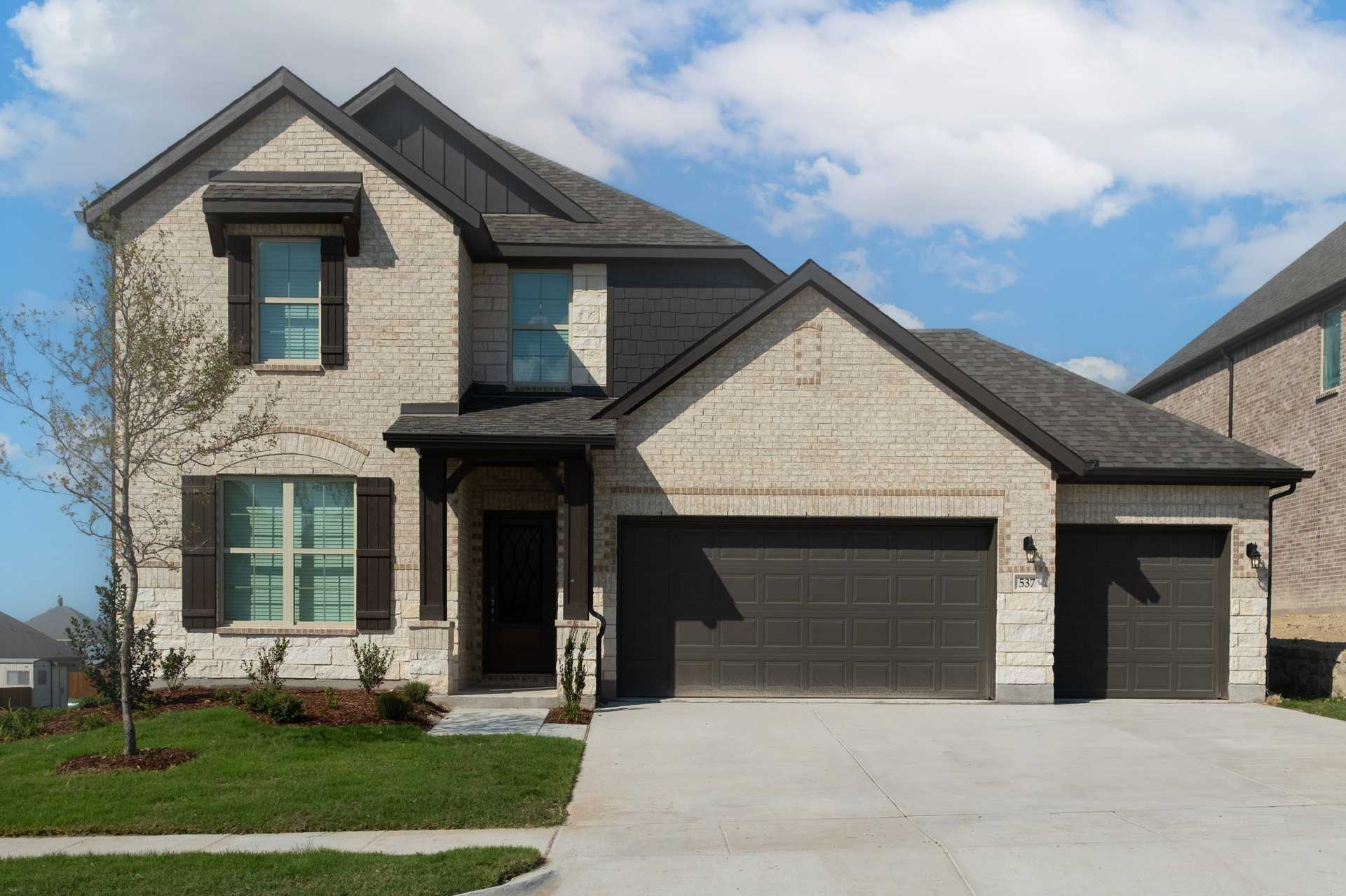 exterior of home with tan brick and white stone