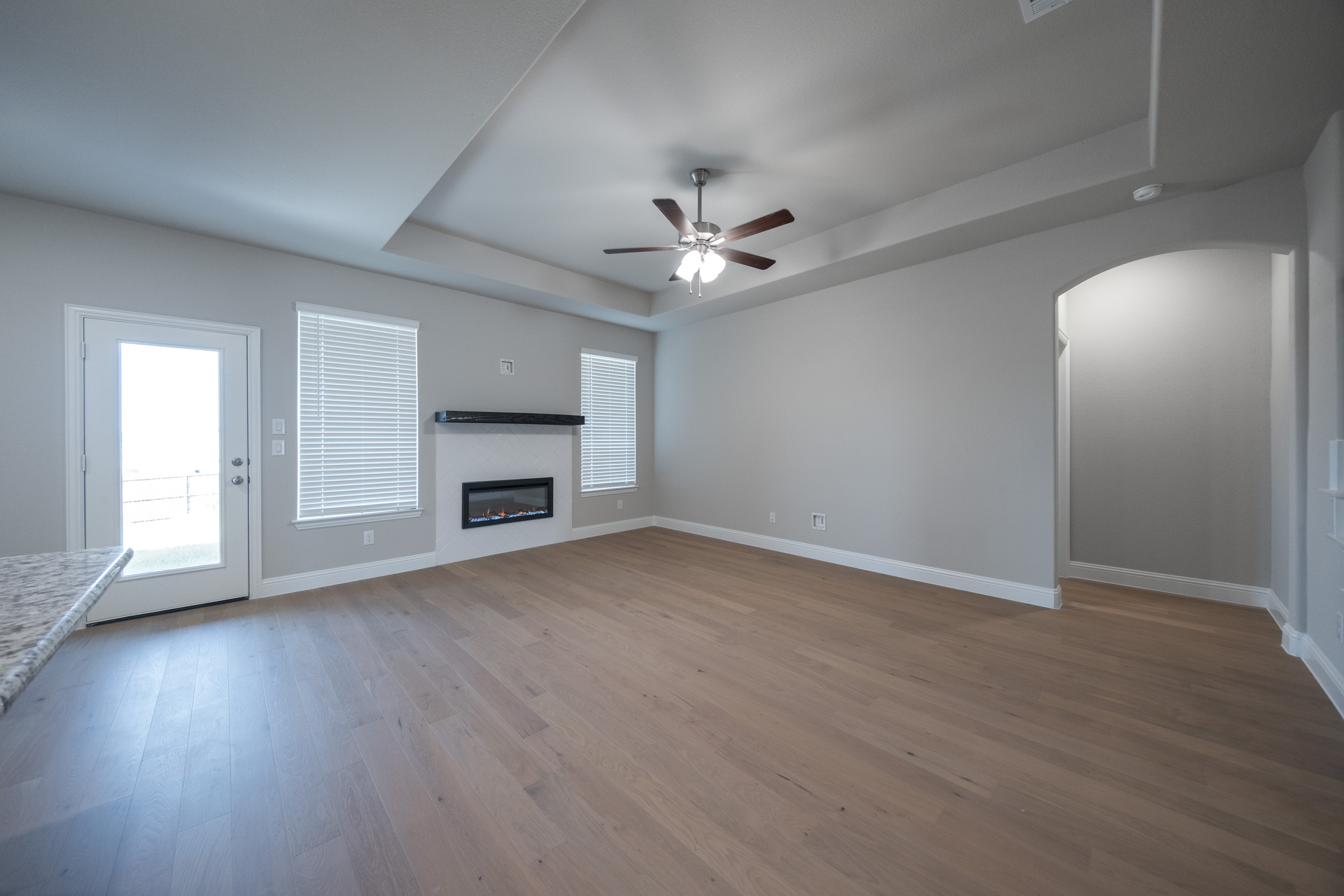 open great room with electric fireplace and hardwood flooring