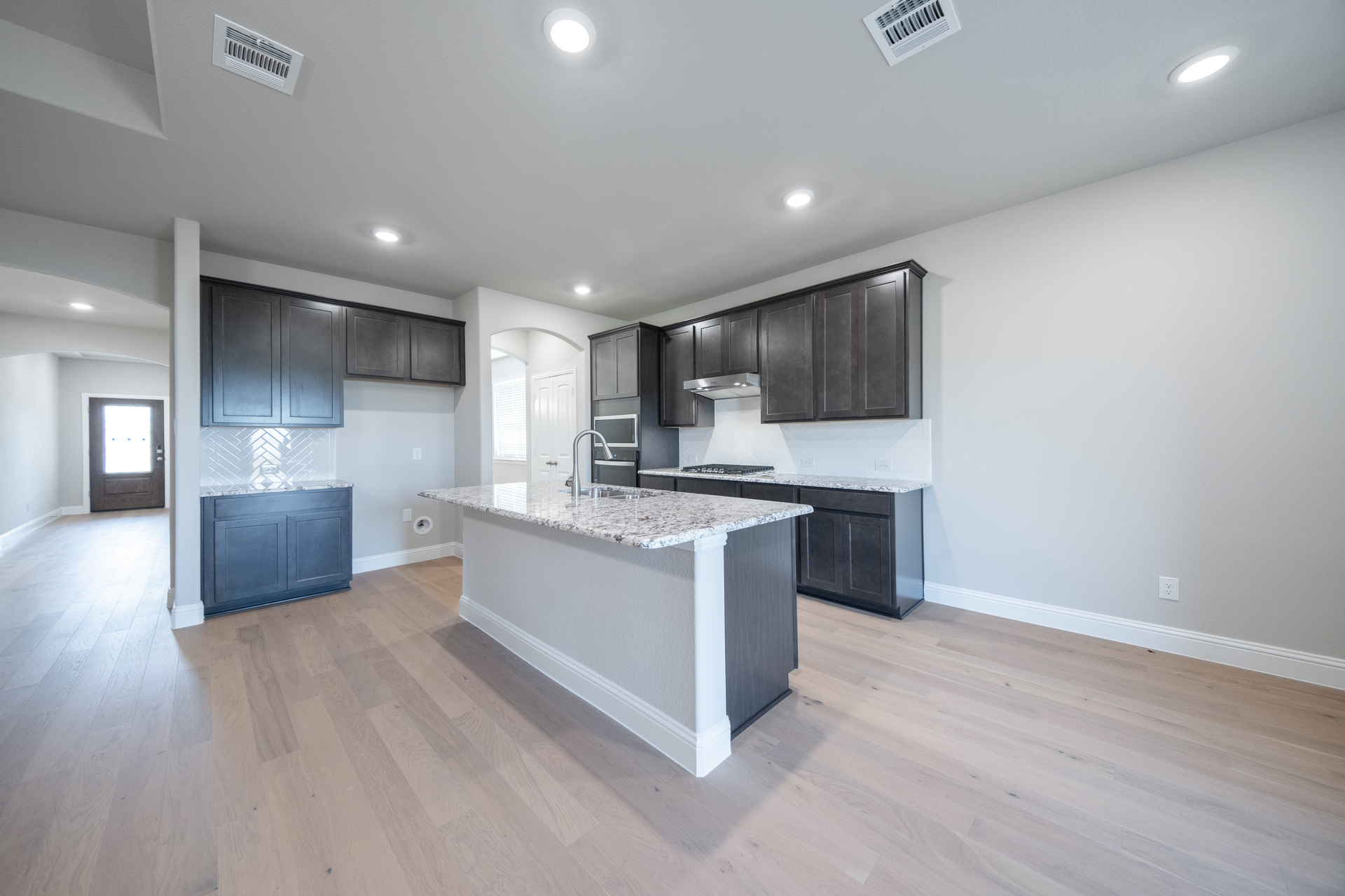 open kitchen with brown cabinets and hardwood flooring