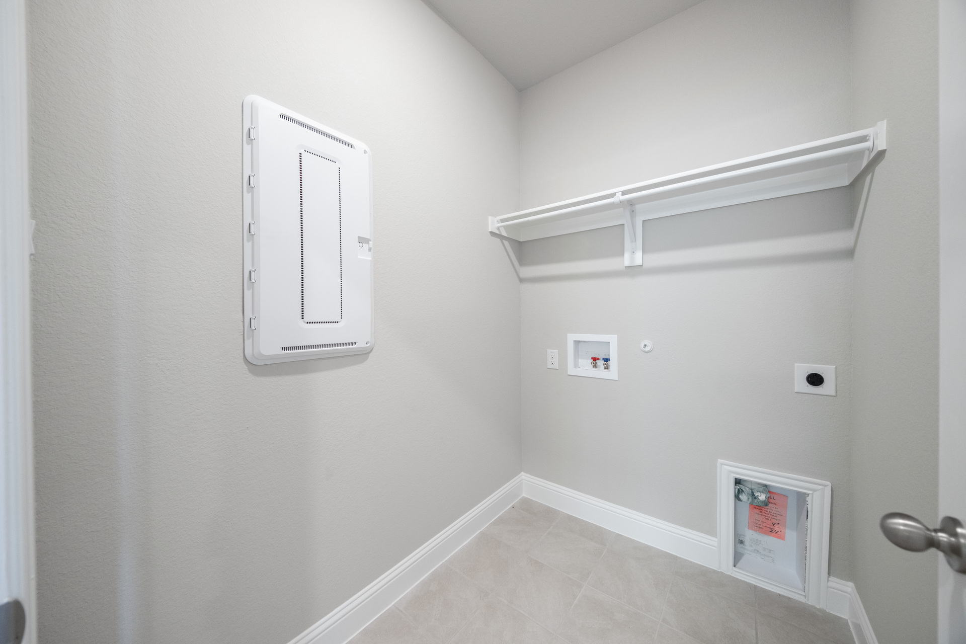 laundry room with tile flooring and storage shelf