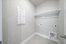 laundry room with tile flooring and storage shelf