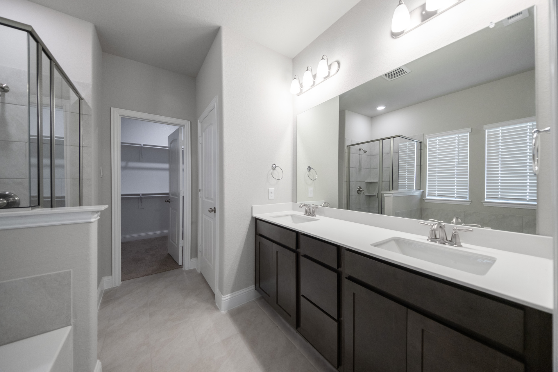 primary bathroom with double sinks and tile flooring