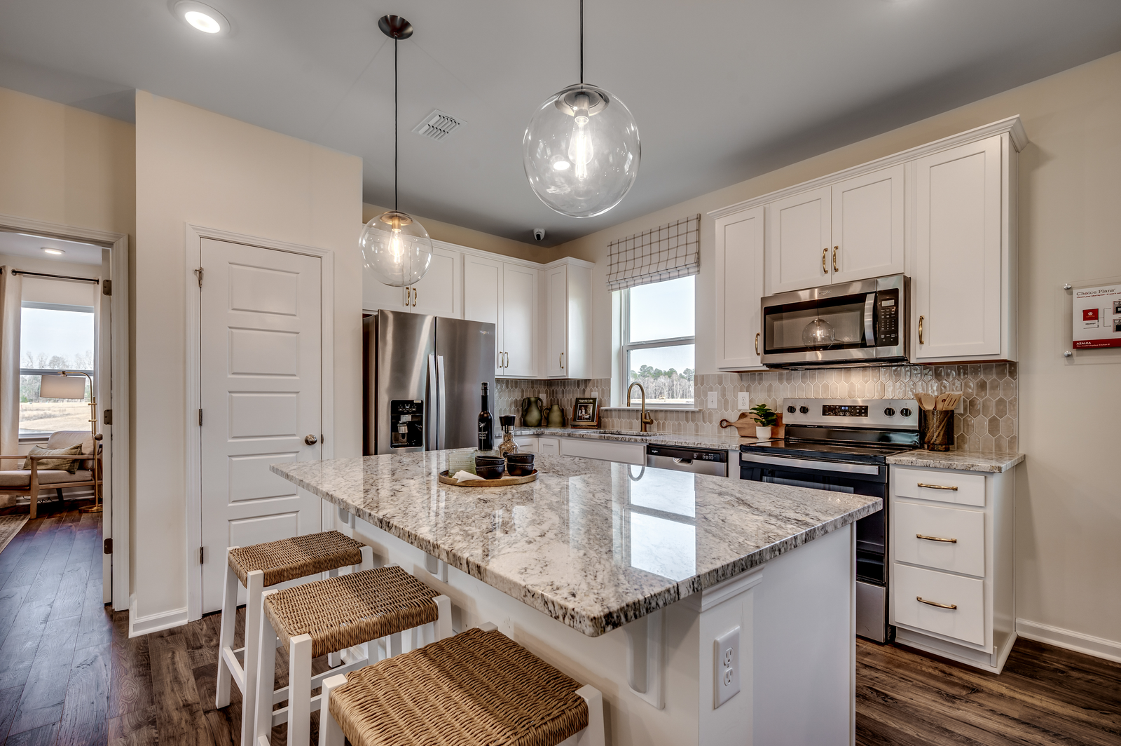 great room with white cabinets and large island