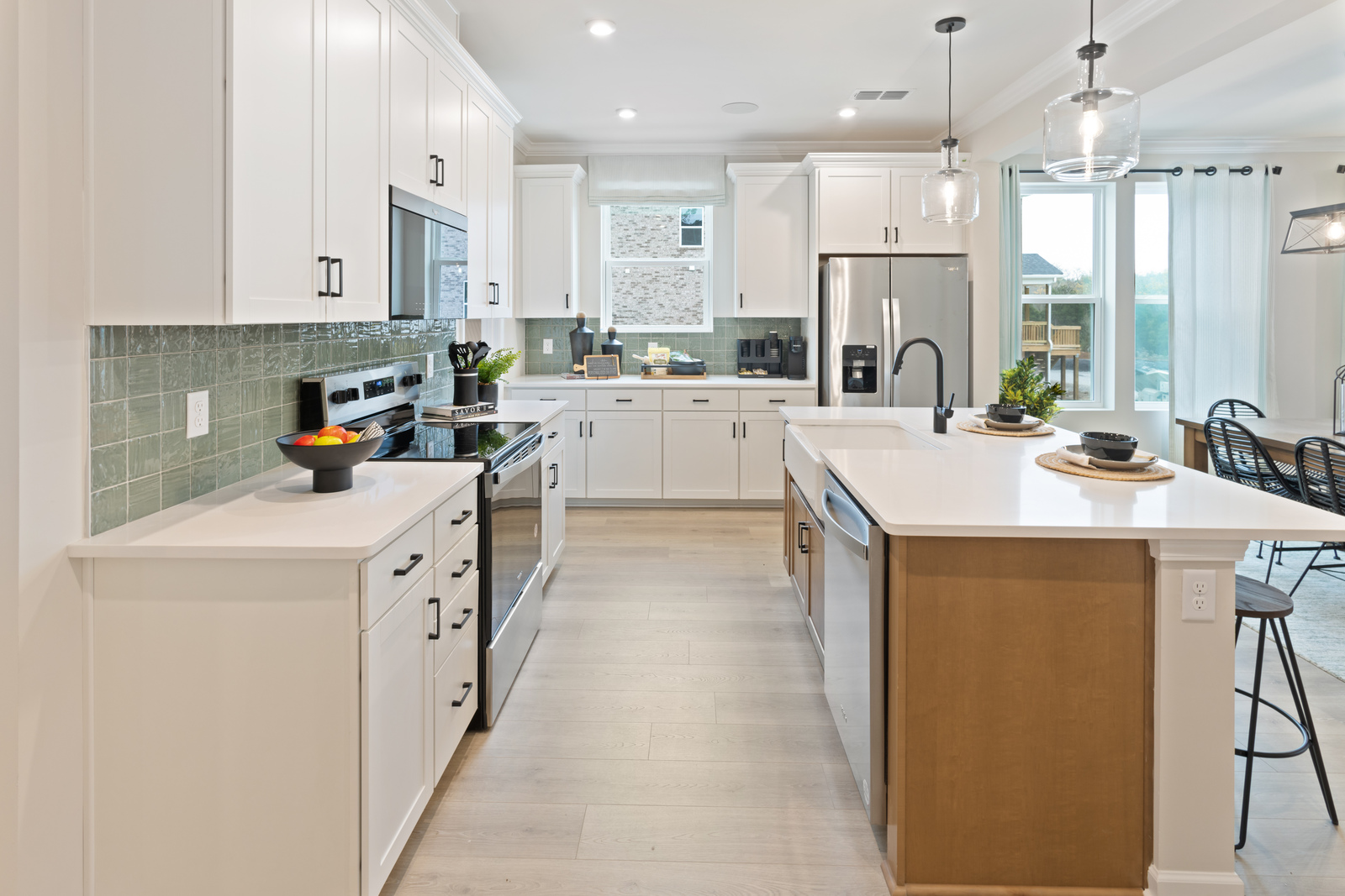 kitchen with white cabinets, green backsplash, and an island