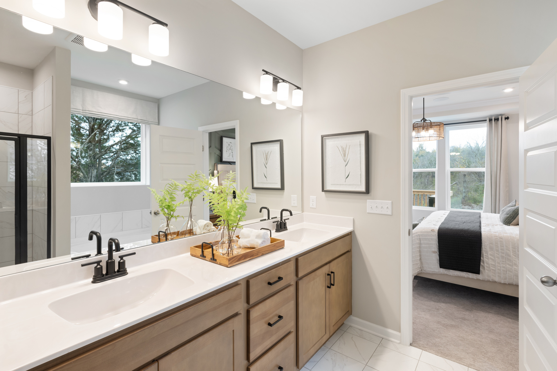primary bathroom with double sink vanity, natural wood cabinets and white countertops