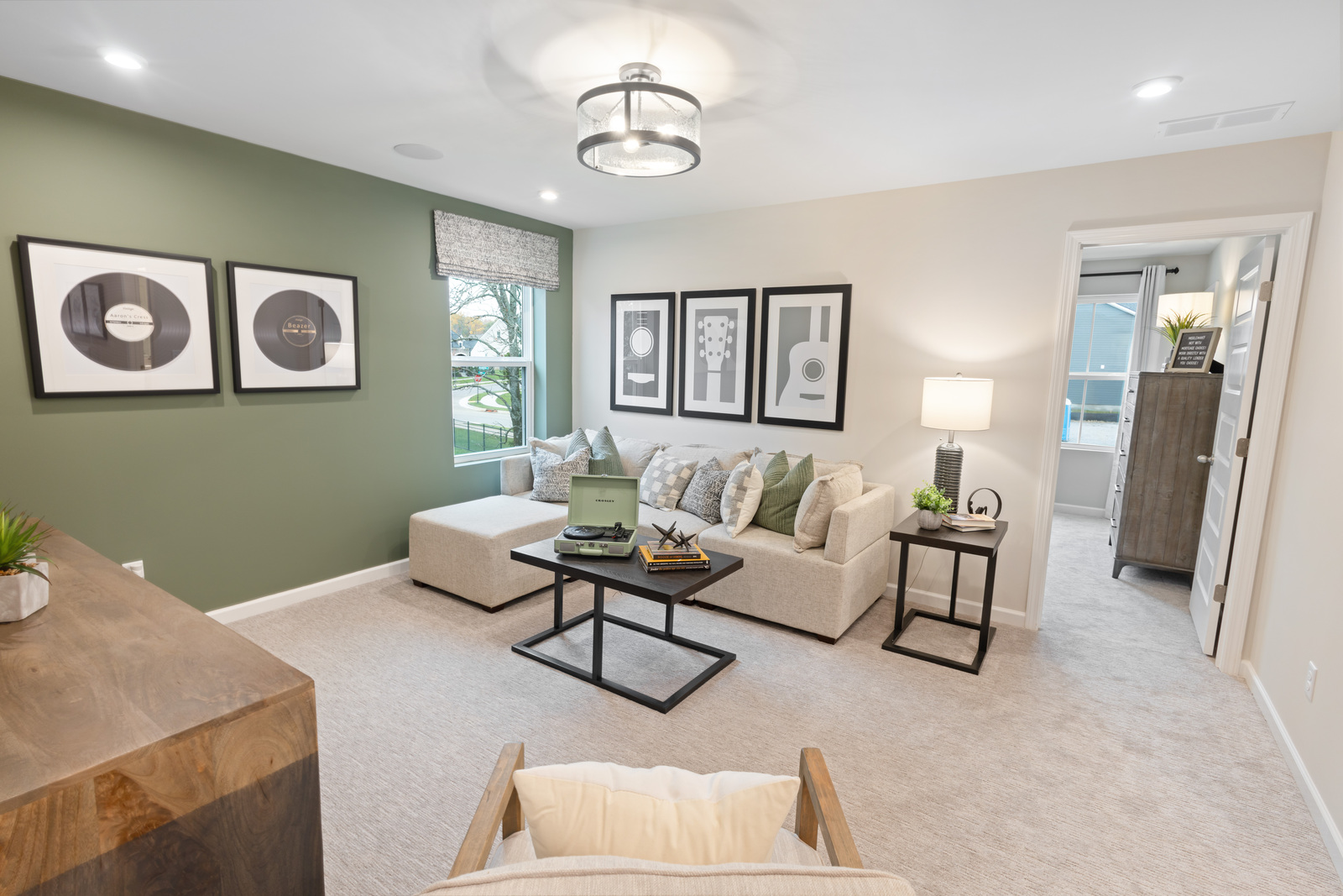 loft space with white sofa, coffee table, and green accent wall
