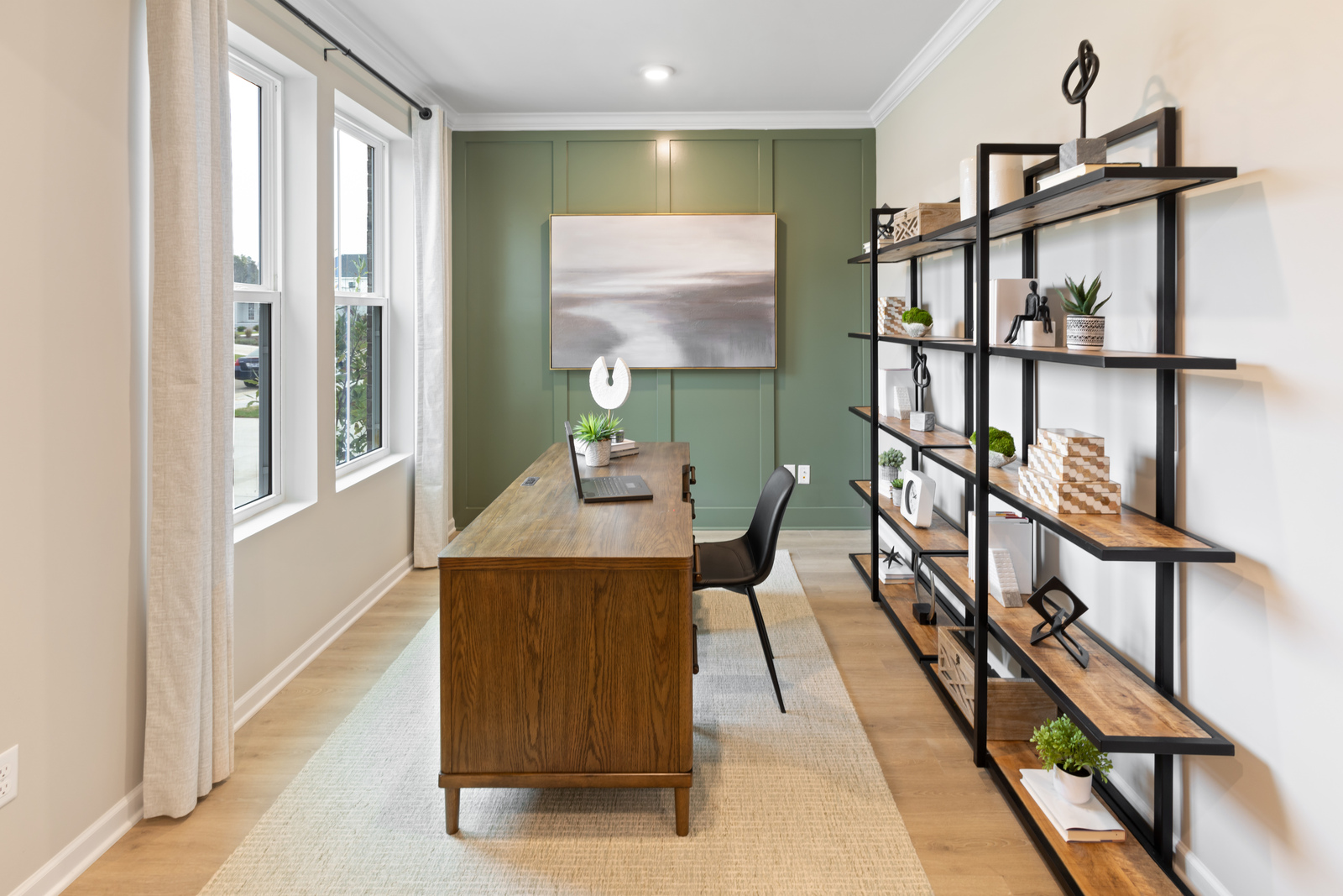 study with green accent wall, a bookshelf, and a desk