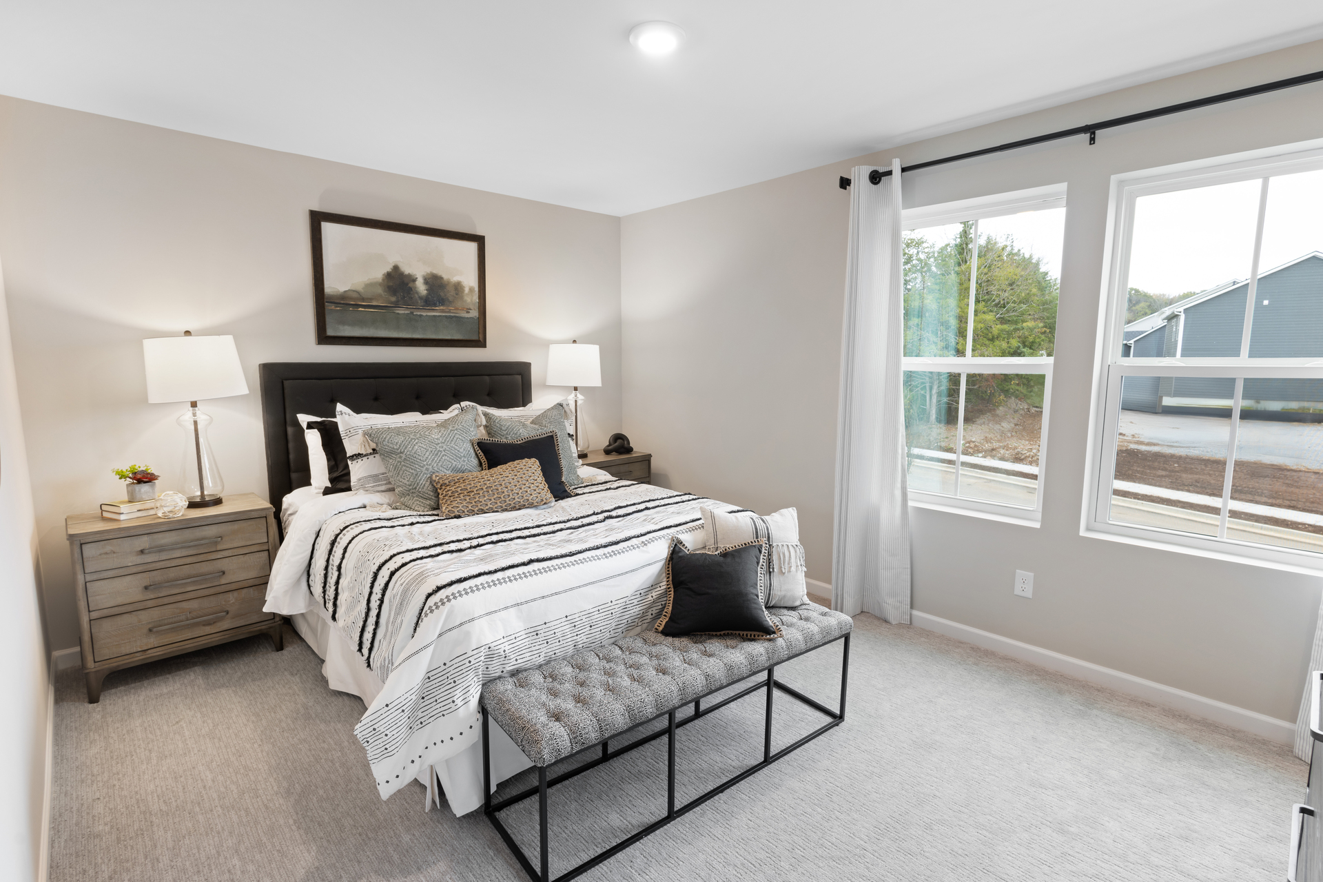 secondary bedroom with bed, nightstands, and large windows
