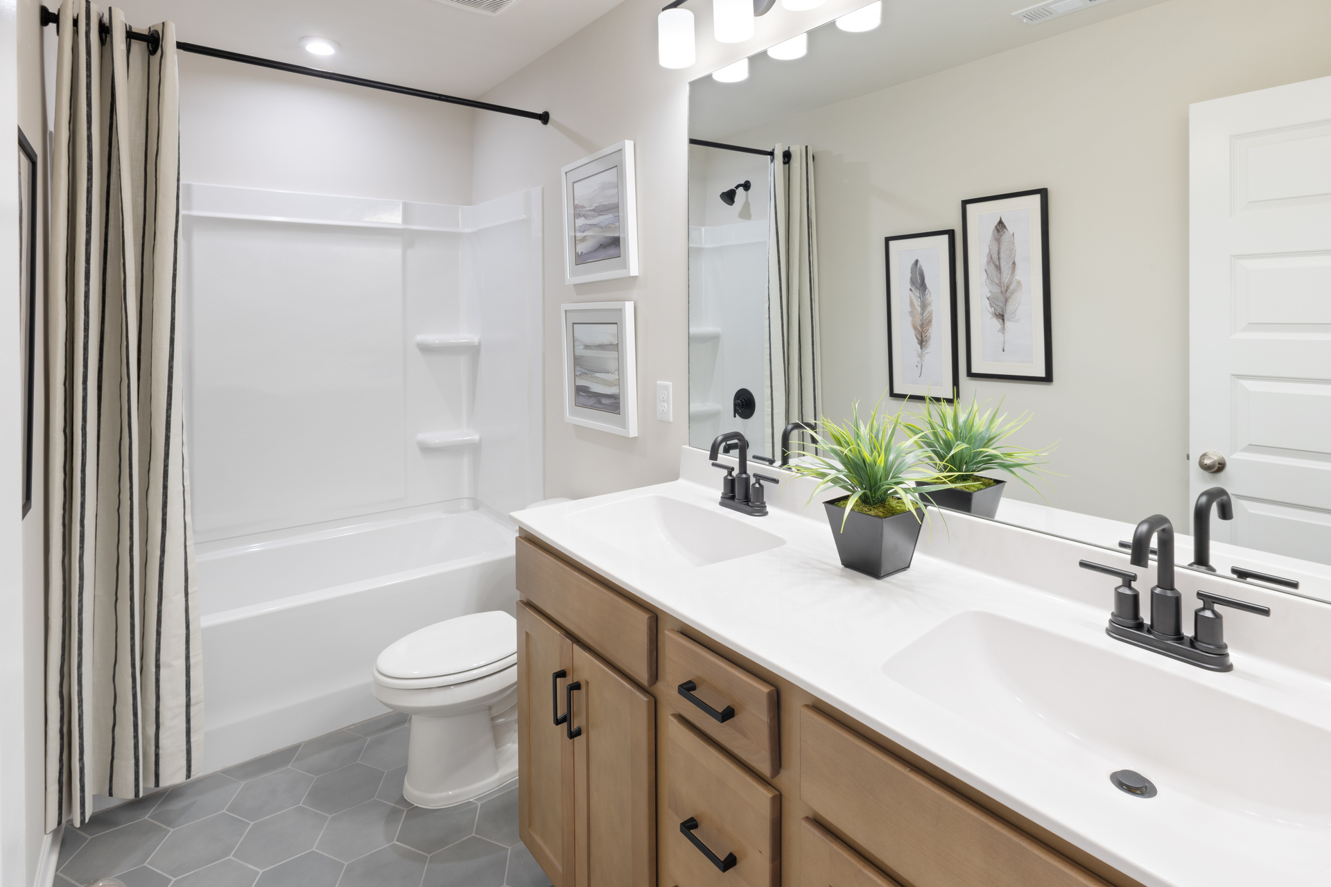 bathroom with double sink vanity, shower and tub combination, and gray tile flooring