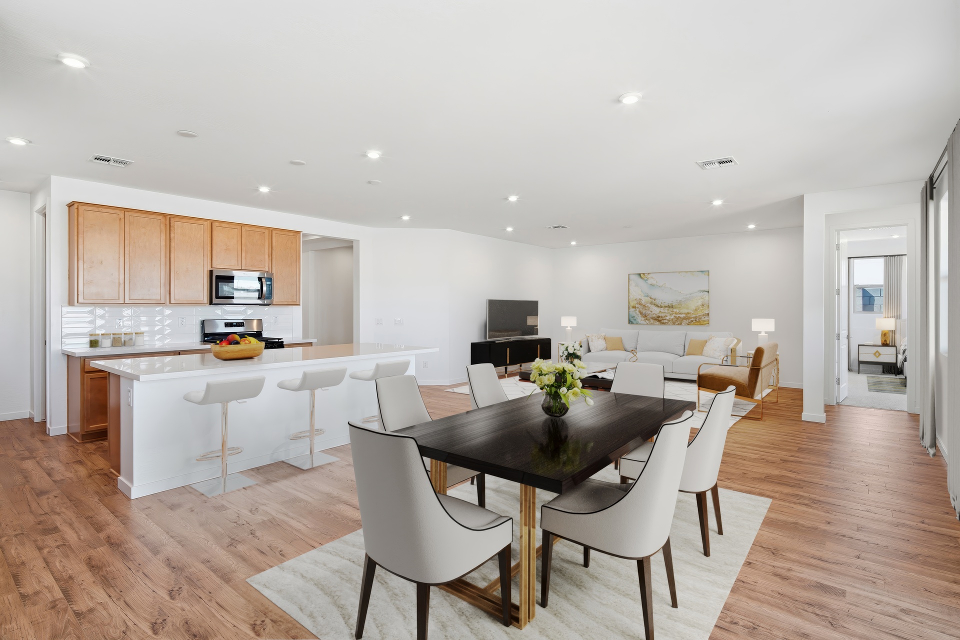 open-concept space with a black dining table, white chairs, and a white rug
