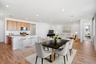 open-concept space with a black dining table, white chairs, and a white rug