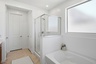 spacious bedroom with a walk-in shower and a soaking tub