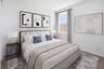 bedroom with a large white bed, black nightstands, and a neutral-colored rug