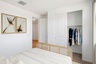 bedroom with white bed, white rug, and oak bed frame