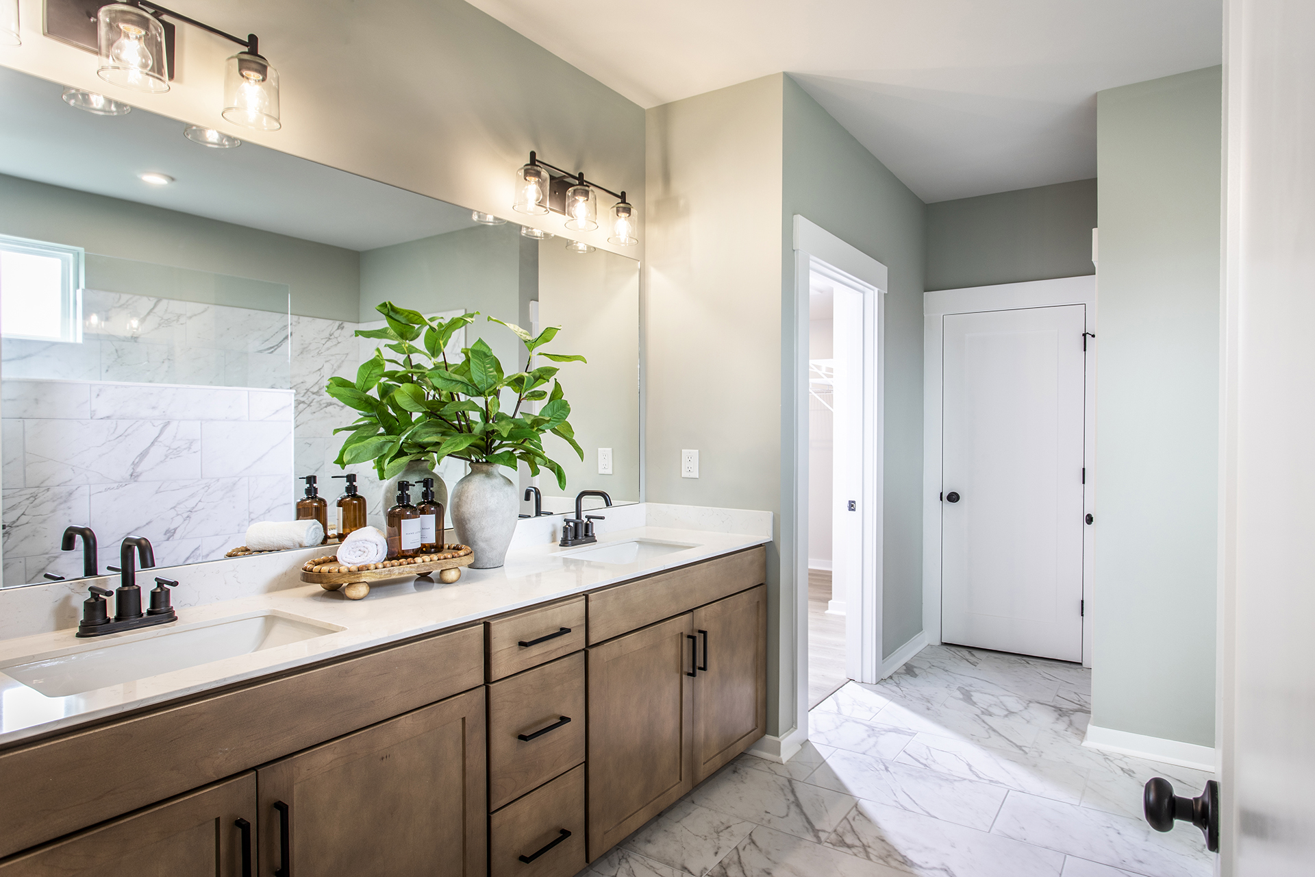primary bathroom with wood cabinets and tile flooring