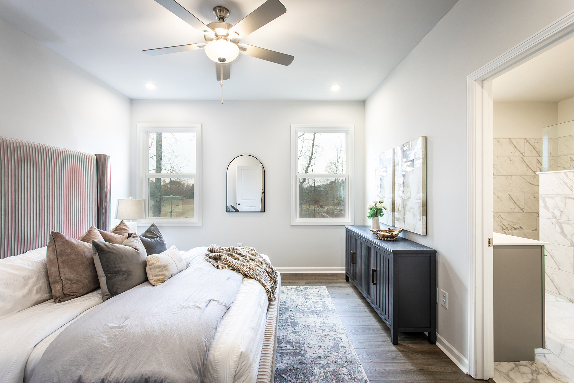 primary bedroom with windows and hard surface floors